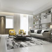 A living room with white walls and grey furniture.